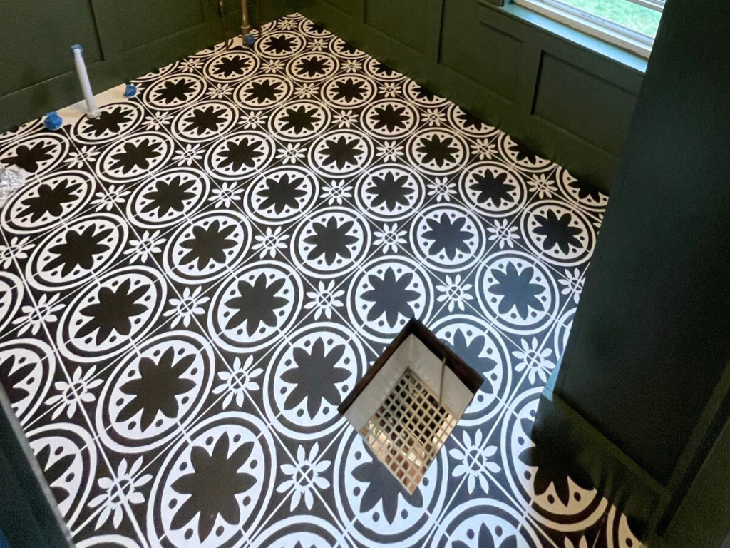 close-up-image-of-stenciled-black-and-white-hardwood-flooring-in-a-green-bathroom-with-board-and-batten
How to stencil hardwood floors